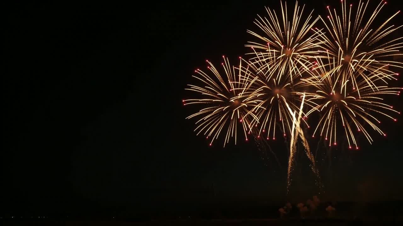 Golden and red fireworks illuminating the night sky